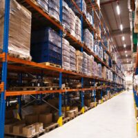 interior-large-distribution-warehouse-with-shelves-stacked-with-palettes-goods-ready-market-scaled